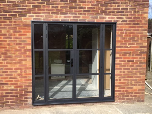 heritage style patio doors with black slimline aluminium frames, set into red brick wall