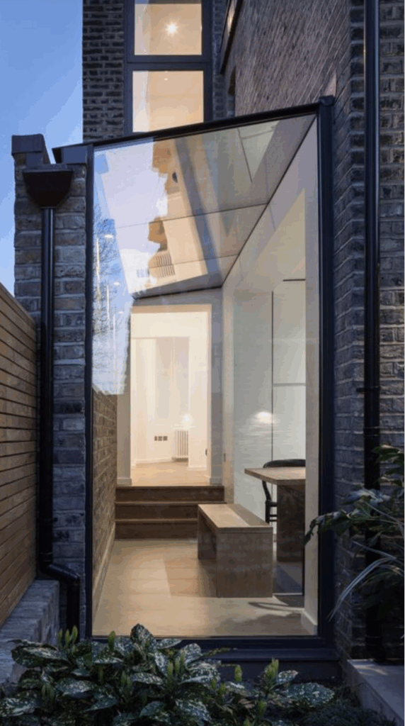 Structural glass side extension in London with frameless glazing joining traditional brickwork