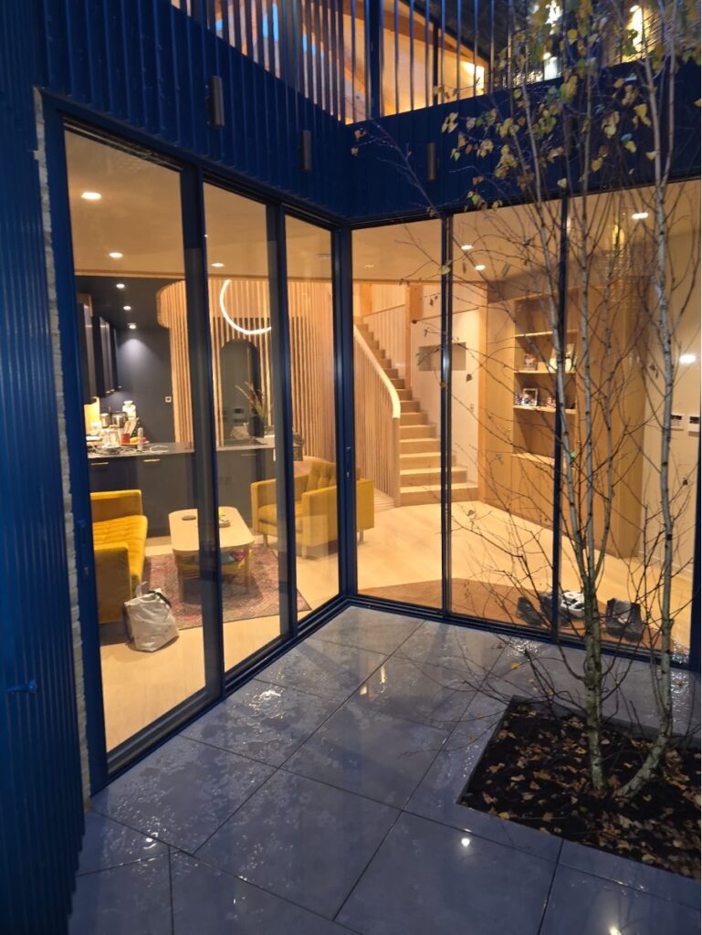 Frameless corner structural glazing system with minimal frame aluminium detailing in Surrey residence